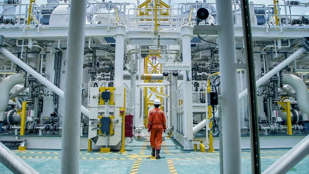 An employee in the middle of an industrial plant
